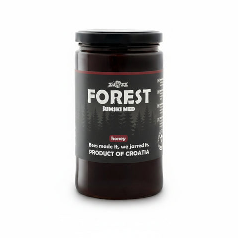 Jar of honey labeled 'Forest' with a black lid on a white background